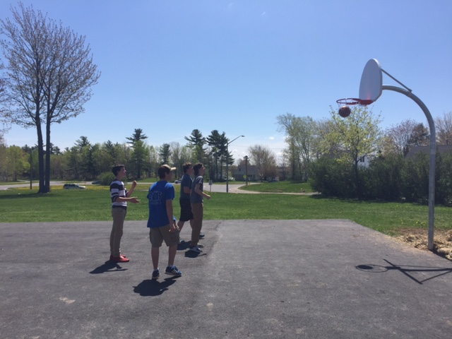 Harold Peterson Middle School students play a game of basketball on school grounds.